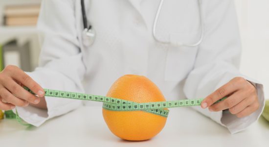 close-up-nutritionist-measuring-orange